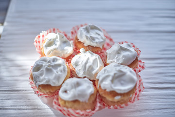 Cupcakes with white cream on a wooden background
