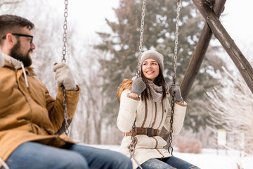 Couple on swings in the snow