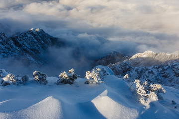 Amazing landscape of rugged mountain ridge raising above the clouds and fog