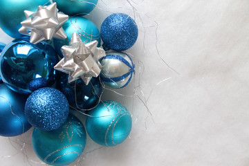 Silver and blue christmas balls on white snowy background