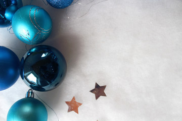 Silver and blue christmas balls on white snowy background