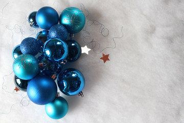 Silver and blue christmas balls on white snowy background