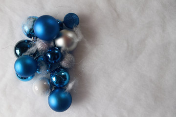 Silver and blue christmas balls on white snowy background