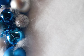 Silver and blue christmas balls on white snowy background