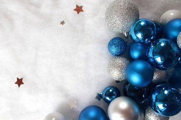 Silver and blue christmas balls on white snowy background