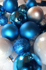 Silver and blue christmas balls on white snowy background