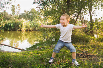 Cheerful and naughty boy playing in nature