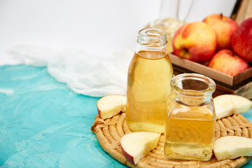 Glass Bottle of apple organic vinegar on blue background.