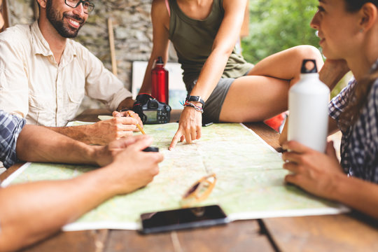 Group of hikers sitting together planning a hiking route looking at map