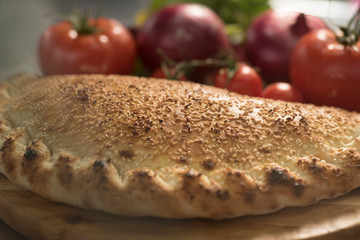 Hot pizza slice with melting cheese on a rustic wooden table.