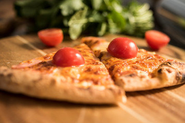 Hot pizza slice with melting cheese on a rustic wooden table.