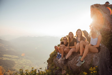 Switzerland, Grosser Mythen, four happy girlfriends on a hiking trip having a break at sunrise