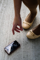 Woman legs with broken phone