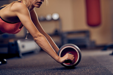 Close up of beautiful woman doing exercises for abs. Healthy lifestyle concept. Gym interior.