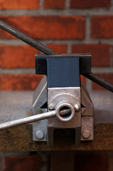 Etwas in den Schraubstock zwingen