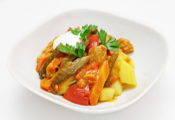 Dish of vegetables and meat on a white background