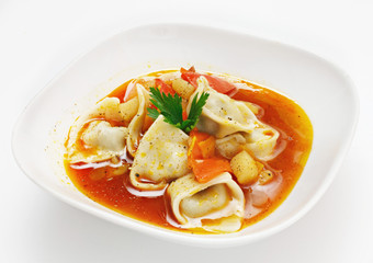Soup with vegetables and pasta on a white background