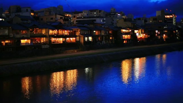 Night view on the Kamogawa river embankment in Kyoto. Restaurant lights reflected in the river.