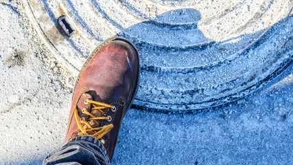 First person view of shoe. Winter walk concept. View from above on brown boot. Blank copy space background