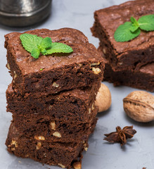 stack of baked square pieces of chocolate brownie pie with walnuts