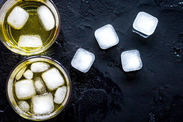 glass of scotch on dark background top view