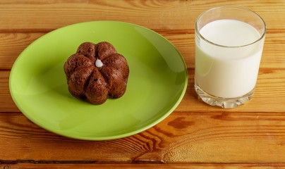 Baking on a plate and a glass of milk on a wooden table.