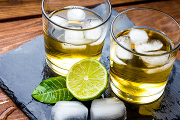 glass of whiskey on wooden background