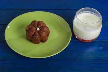Cake on a plate and a glass of milk on the table.