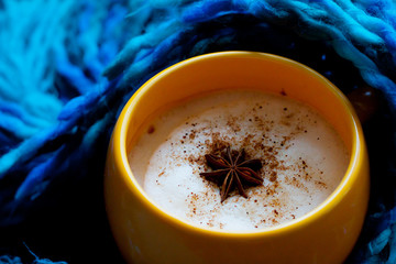 Cup of hot coffee on rustic wooden table, closeup photo warm sweater with mug, winter morning concept, top view