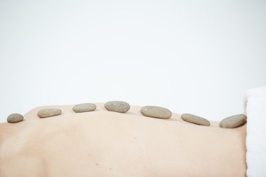 Hot stone massage therapy at beauty center.