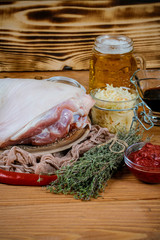 Close up view of chef cooking Bavarian pork knuckle with glass of beer and sauerkraut, thyme and paprika. cooking recipe photo background