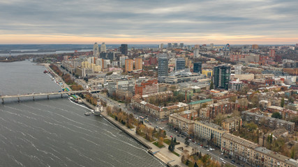 Fototapeta na wymiar Drone's eye view of Dnipro city downtown on coast of Dnieper river. Fly over cityscape with buildings.