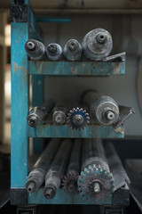Beautiful metal industrial machinery steel cogs in a rustic industrial factory setting. Well used processing machinery parts.
