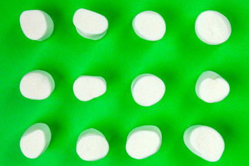 sweet marshmallow, candy on green background, top view