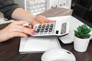 Business woman working with financial data hand using calculator