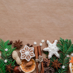 Christmas dekoration with spices and cookies in the shape of snowflakes, cinnamon sticks and star anise on dark brown paper background. Top view.