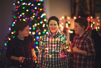 Brothers having fun with Christmas tree lights