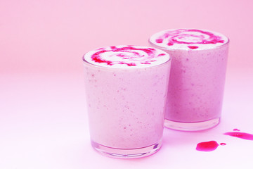 Smoothie with raspberry, banana, and milk on wooden background. Minimal and modern summer concept.