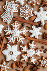 Christmas dekoration with spices and cookies in the shape of snowflakes, cinnamon sticks and star anise on dark brown paper background. Top view.