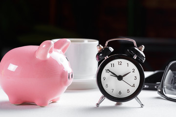 Alarm clock and piggy bank concept for saving time