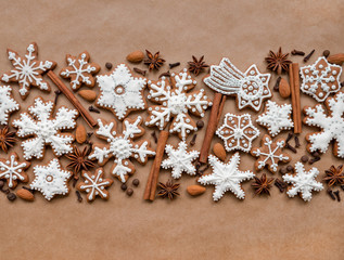 Christmas dekoration with spices and cookies in the shape of snowflakes, cinnamon sticks and star anise on dark brown paper background. Top view.