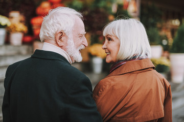 Back view portrait of happy bearded man and his wife looking at each other and smiling