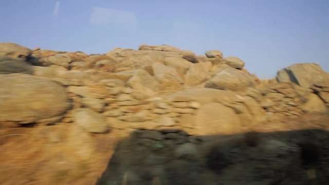 Rocks and cacti along the road, seen out of window on mediterranean island