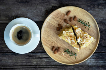 The top view on a cup of coffee with dessert on a wooden table