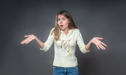 Woman with shocked facial expression. The brunette with surprise and indignation raised her hands...