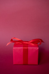 Red gift box on red background.  Copy space.
