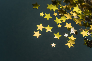 Golden confetti stars scattered on the surface.