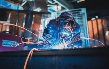 london, england, 02/02/2018 A vibrant action shot of a skilled working metal welder in action,...