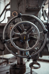 Obraz premium Beautiful matte silver metal industrial machinery steel cog handles in a rustic industrial factory setting. Well used processing machinery parts.