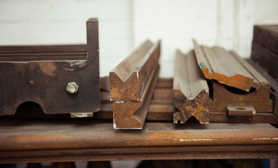 Rusty orange Vintage lead letterpress printing blocks against a weathered metal drawer background with bokeh.